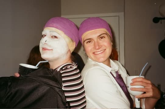 The two of us at a costume party in face masks and purple wigs