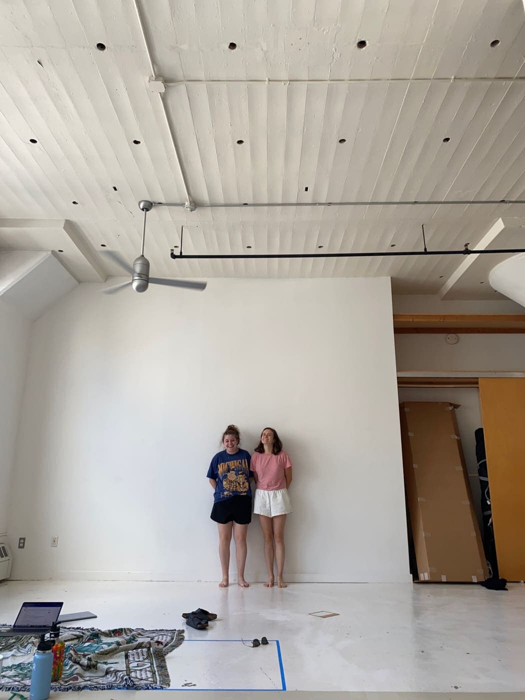 The two of us standing against the wall of a big, empty white loft