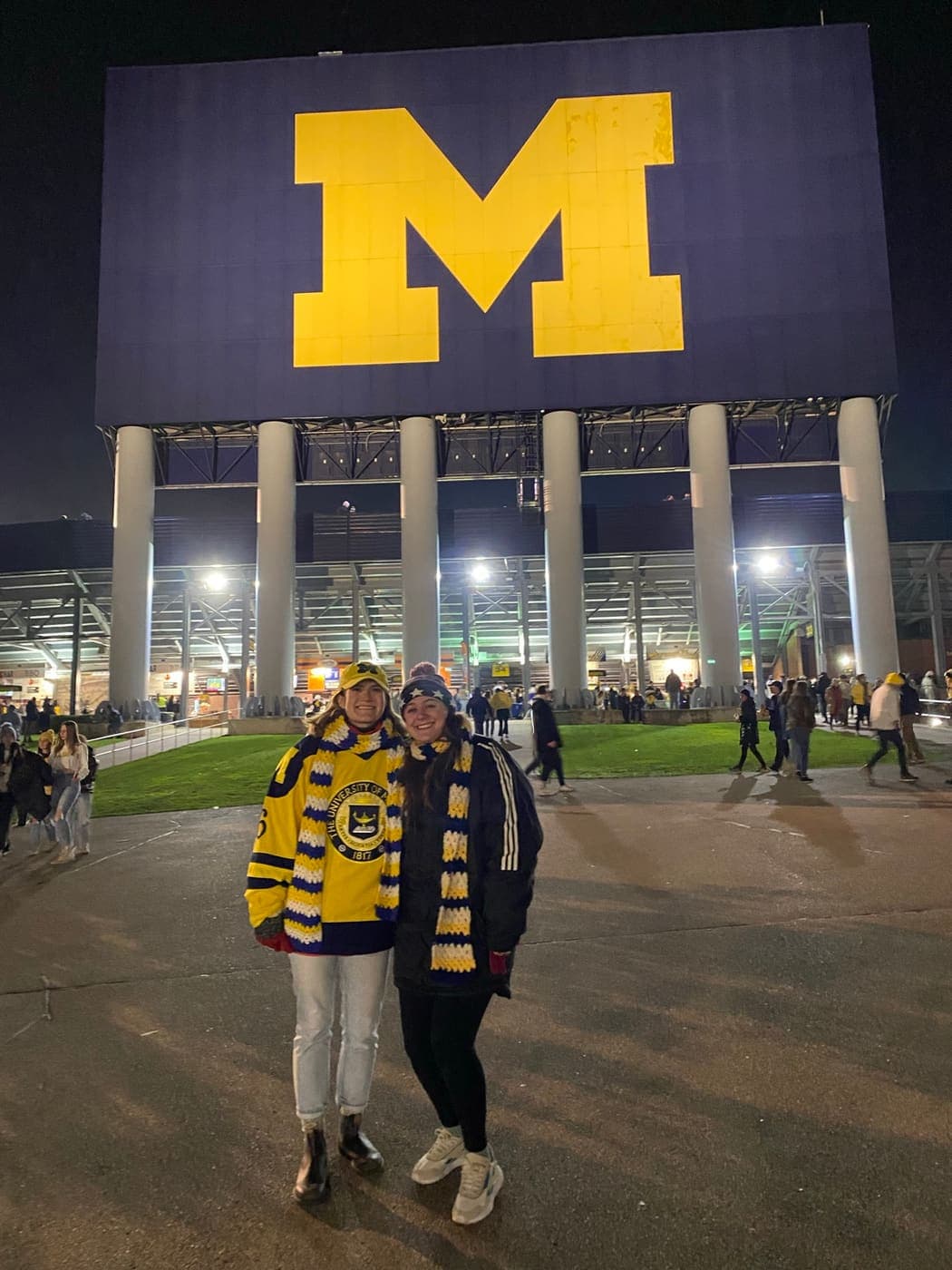 The two of us in Michigan scarves outside the Big House at night