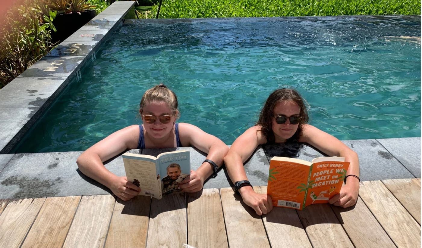 The two of us reading at the edge of a pool in sunglasses