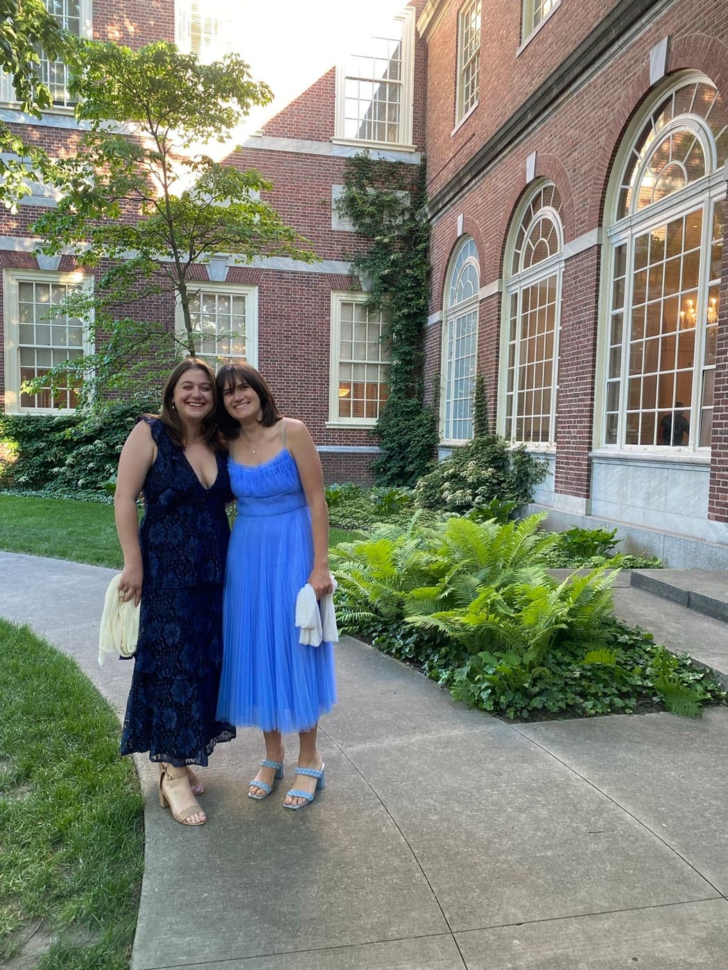 The two of us dressed up for a wedding in front of a brick building